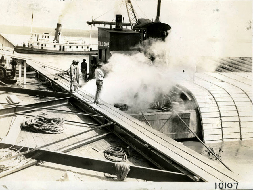 large boats and men laying concrete slabs on a shoreline large boats and men laying concrete slabs on a shoreline